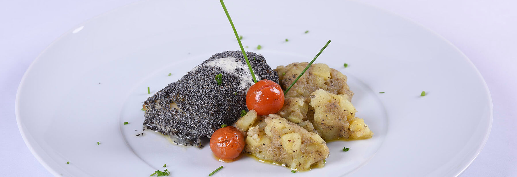 Lombo de bacalhau corado em sementes de papoila e esmagada de azeitona e ervas finas