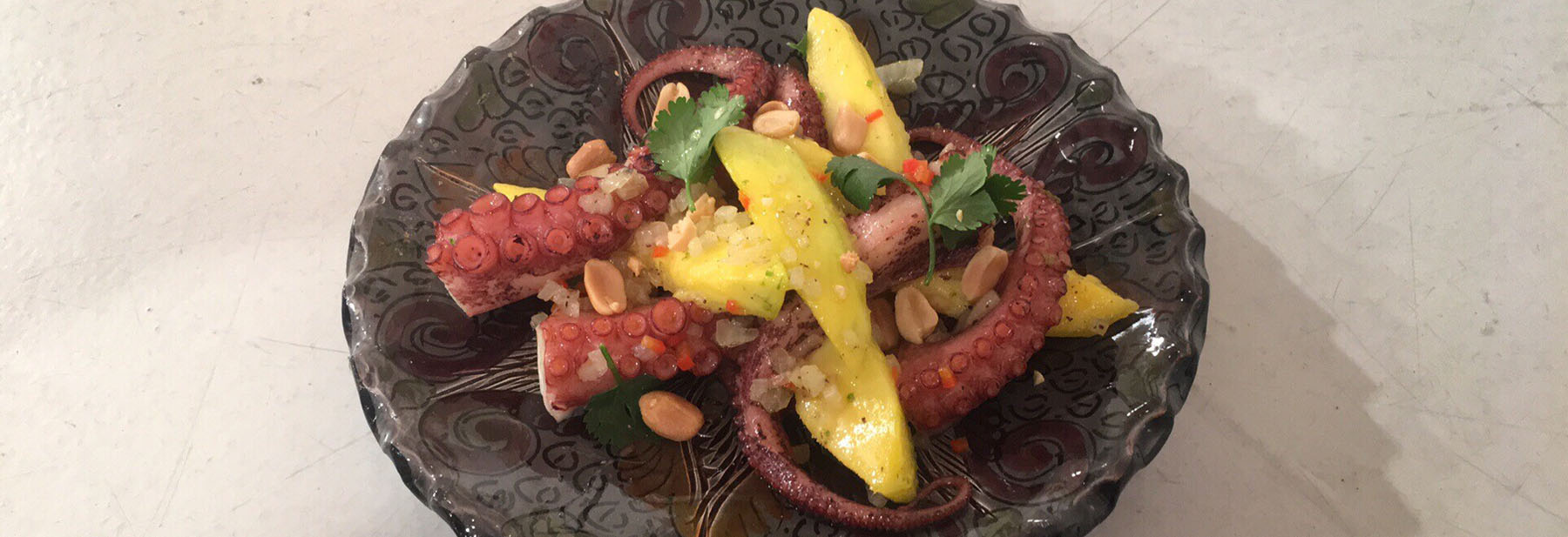 Polvo salteado com manga, lima, mel e amendoim